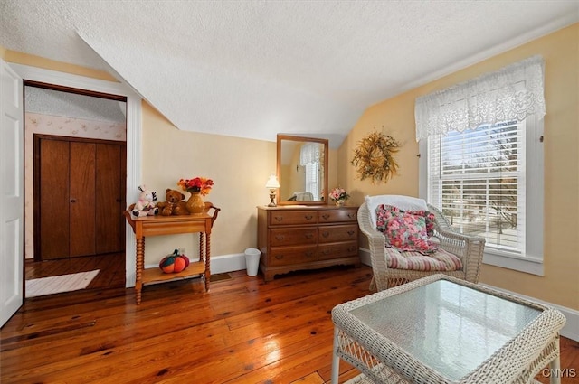 sitting room featuring baseboards, a textured ceiling, lofted ceiling, and wood-type flooring