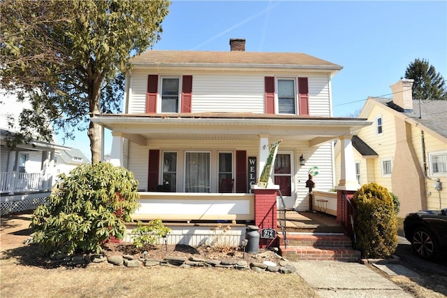 traditional style home featuring a porch and a chimney