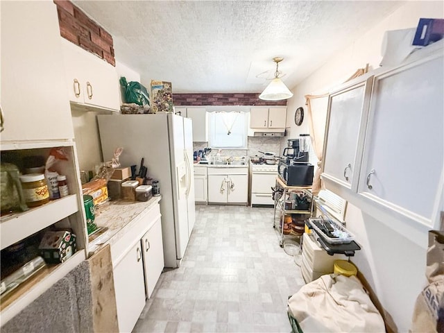 kitchen with white appliances, light floors, light countertops, white cabinets, and a textured ceiling