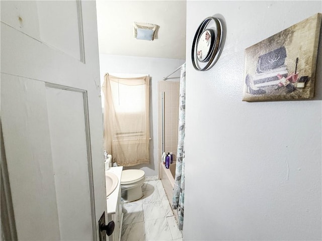 bathroom with curtained shower, toilet, vanity, and marble finish floor