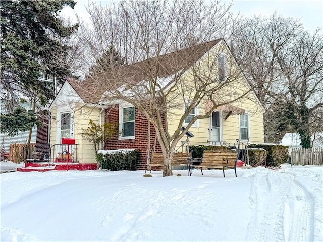 view of front facade with fence and brick siding