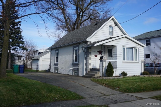 bungalow-style home with fence, driveway, roof with shingles, a front lawn, and brick siding