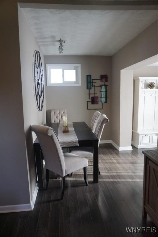 dining room featuring dark wood-type flooring and baseboards