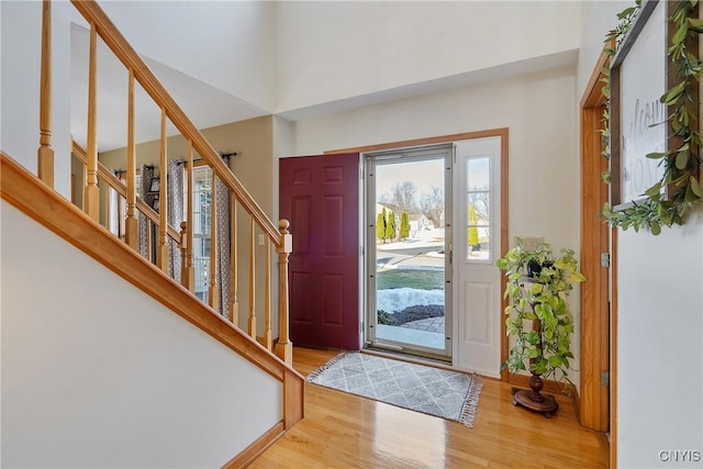 entrance foyer with stairs, baseboards, and wood finished floors