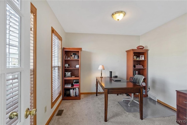 office with visible vents, light carpet, and baseboards