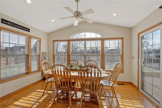 dining room featuring visible vents, baseboards, lofted ceiling, light wood-style floors, and a ceiling fan