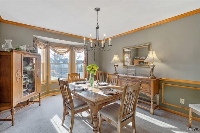 dining space with a chandelier, visible vents, crown molding, and carpet floors