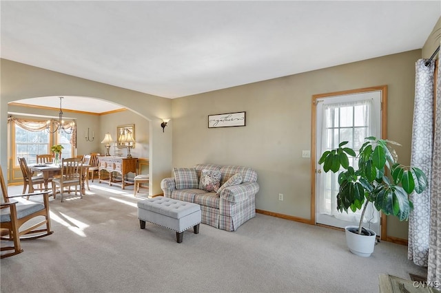 living room with baseboards, arched walkways, carpet, and a healthy amount of sunlight