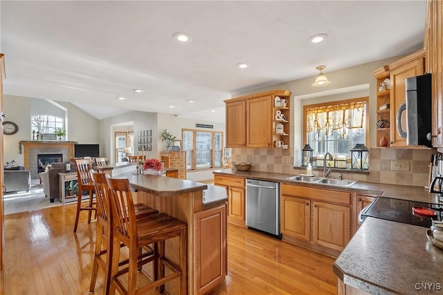 kitchen featuring open shelves, vaulted ceiling, light wood-style flooring, stainless steel appliances, and a sink