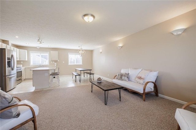 living area with baseboards and light carpet