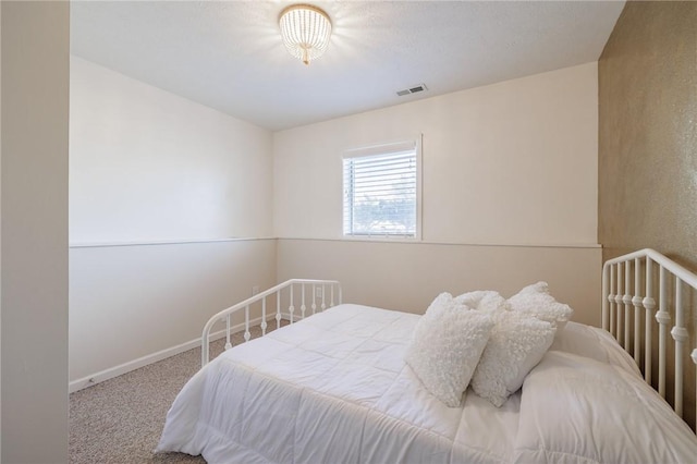 carpeted bedroom with visible vents and baseboards