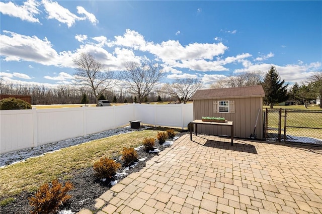 view of patio / terrace featuring an outdoor structure, a fenced backyard, and a shed