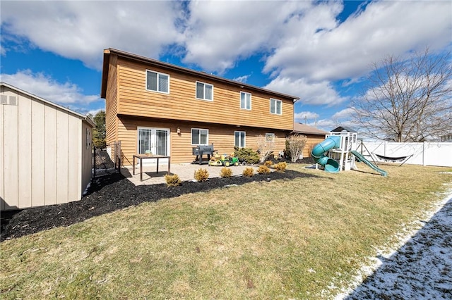 rear view of property with a playground, a yard, a patio area, and a fenced backyard