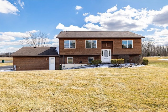 bi-level home with entry steps and a front yard