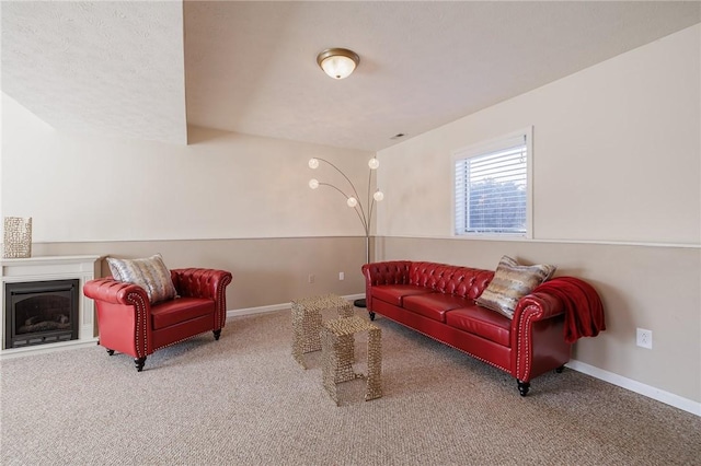 living area featuring a fireplace, baseboards, and carpet floors