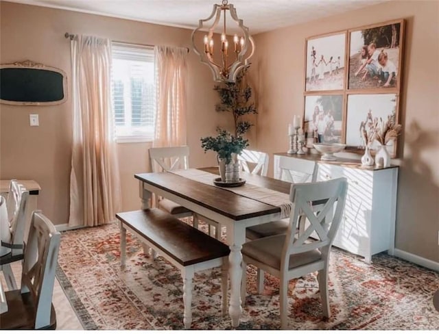 dining room with a chandelier and baseboards