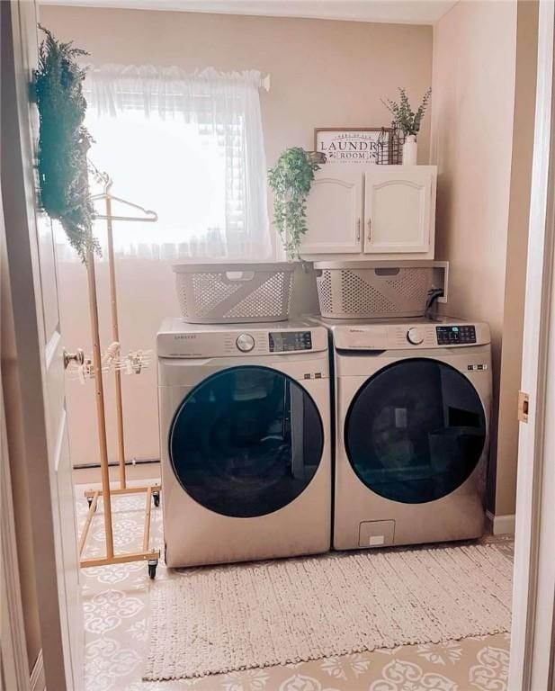 washroom featuring cabinet space and separate washer and dryer