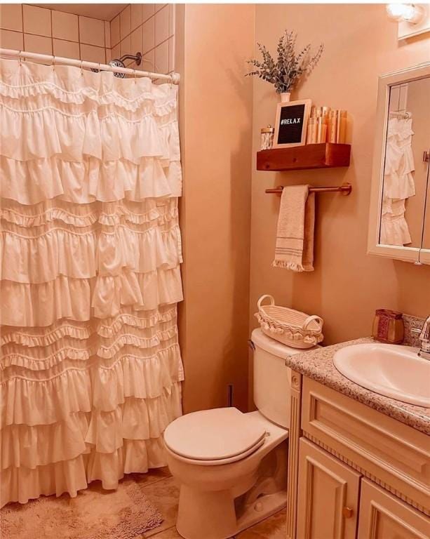 bathroom featuring tile patterned floors, a shower with curtain, toilet, and vanity