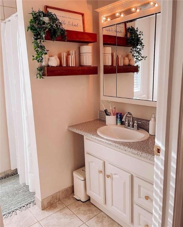 bathroom featuring tile patterned flooring, vanity, a shower with shower curtain, and baseboards