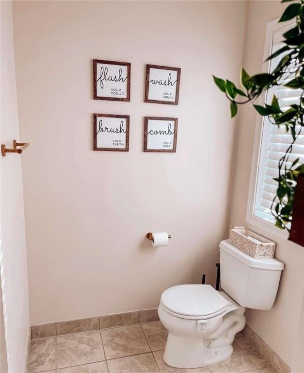 bathroom with tile patterned floors, toilet, and baseboards