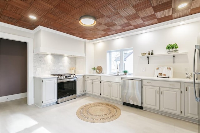 kitchen featuring backsplash, crown molding, light countertops, appliances with stainless steel finishes, and open shelves