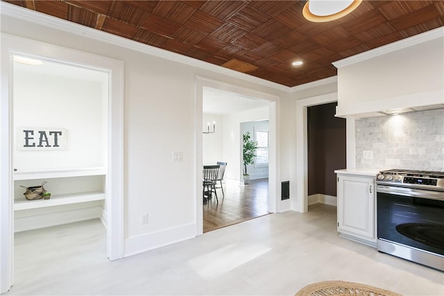 kitchen with tasteful backsplash, gas stove, baseboards, and ornamental molding