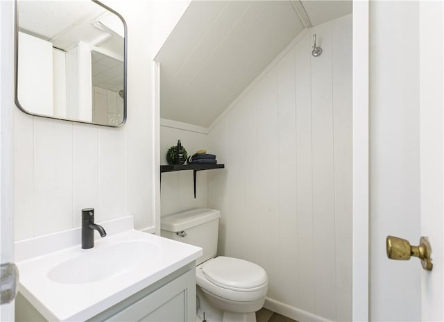 bathroom with vanity, lofted ceiling, and toilet