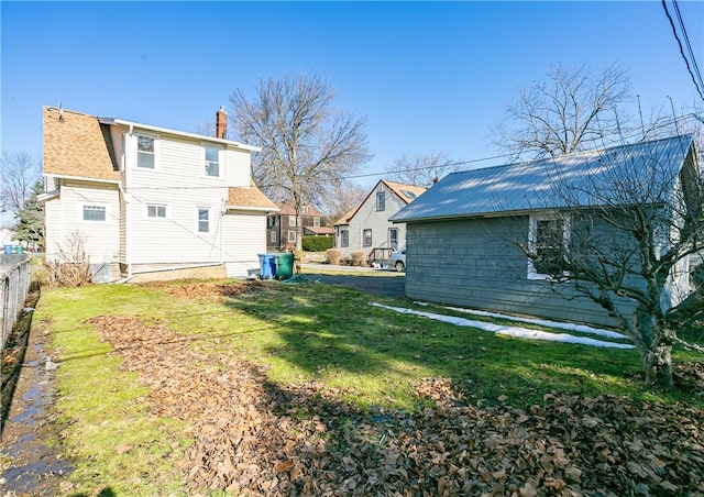 exterior space featuring a yard, a chimney, and fence