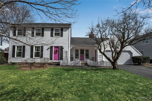 view of front of house featuring aphalt driveway, a garage, a front yard, and a chimney