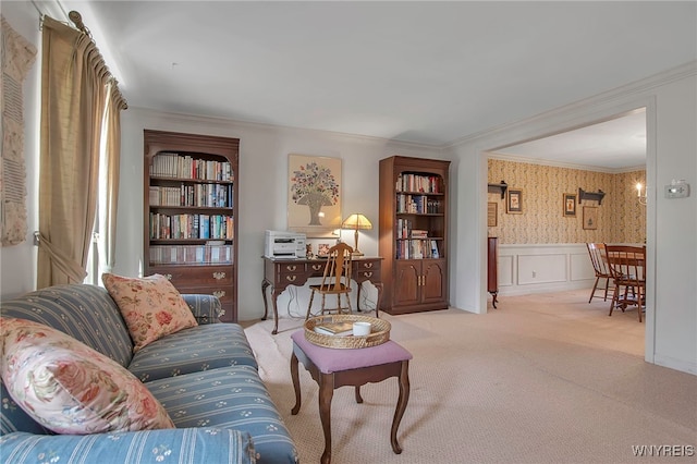 carpeted living room featuring wallpapered walls, a decorative wall, a wainscoted wall, and ornamental molding