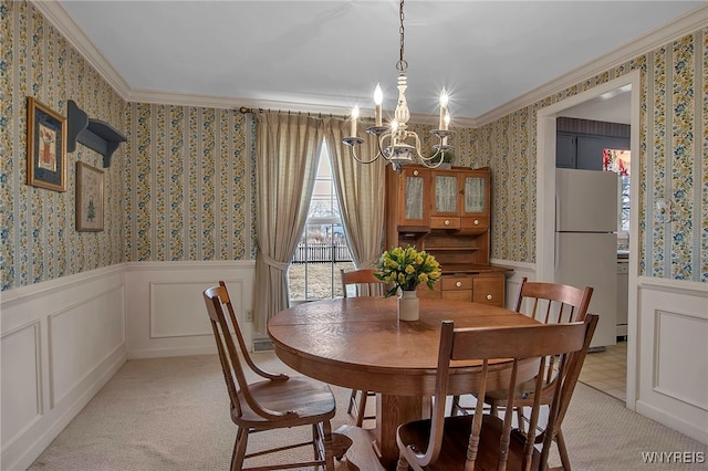 dining area with wainscoting, wallpapered walls, an inviting chandelier, and ornamental molding