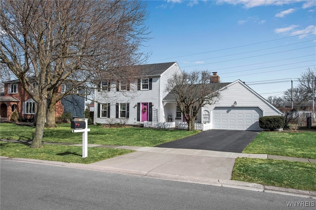 view of front facade featuring a garage, driveway, a chimney, and a front lawn