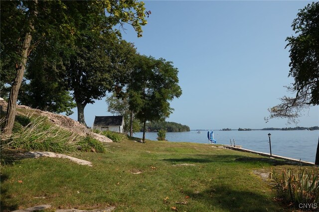 view of yard with a water view and a dock