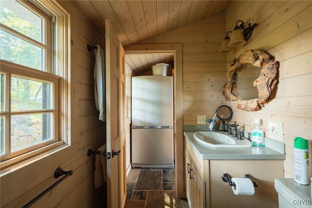 bathroom with wood walls, wood ceiling, vanity, and lofted ceiling