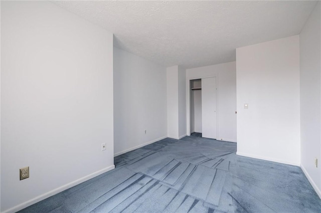 interior space with a closet, baseboards, carpet floors, and a textured ceiling