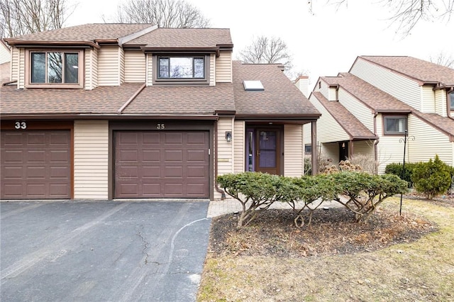 view of front facade featuring an attached garage, driveway, and roof with shingles