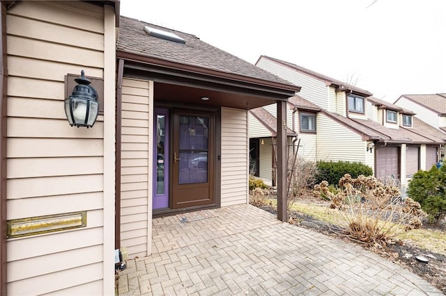 property entrance with roof with shingles