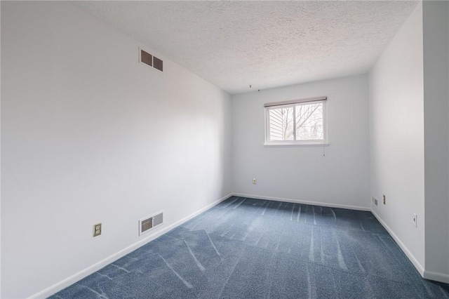 unfurnished room with visible vents, a textured ceiling, baseboards, and carpet