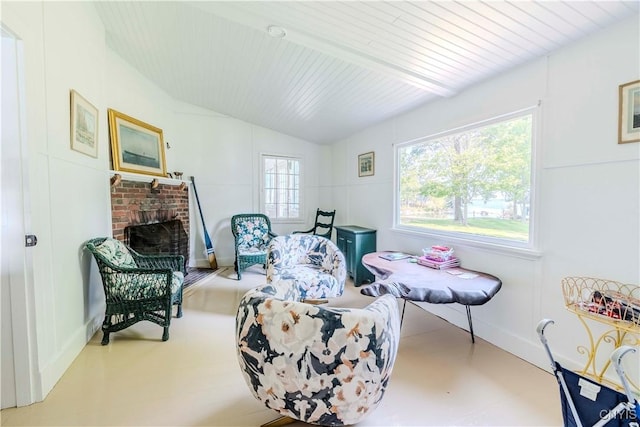 living area featuring a fireplace, baseboards, and lofted ceiling