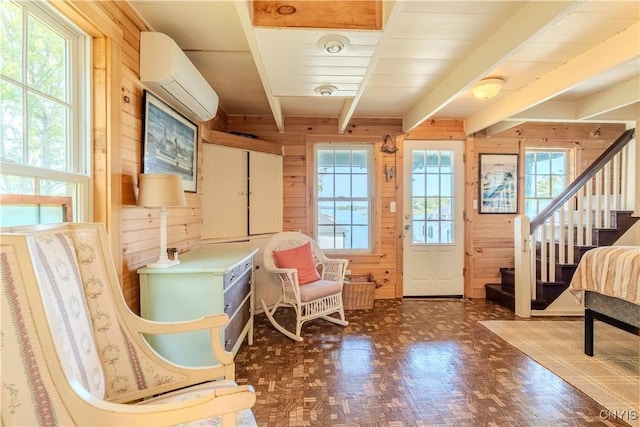 living area with beamed ceiling, wooden walls, an AC wall unit, and stairway