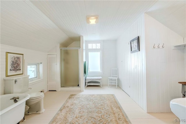 full bathroom featuring a shower stall, a freestanding tub, a healthy amount of sunlight, and lofted ceiling