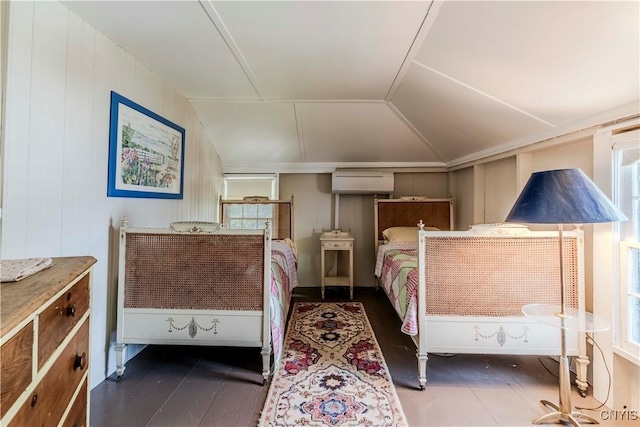 bedroom featuring lofted ceiling and a wall unit AC