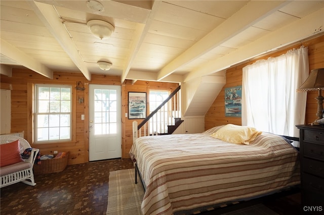 bedroom featuring wooden walls and beamed ceiling