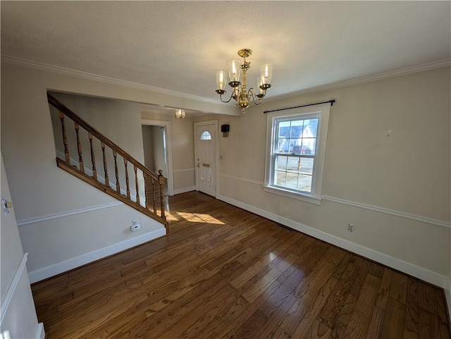 entryway with stairs, wood finished floors, baseboards, and ornamental molding