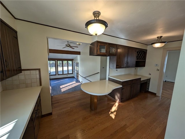 kitchen with dark brown cabinets, baseboards, light countertops, dark wood-style flooring, and open shelves