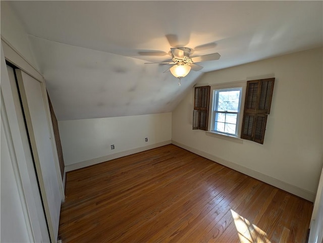 additional living space featuring hardwood / wood-style floors, vaulted ceiling, a ceiling fan, and baseboards