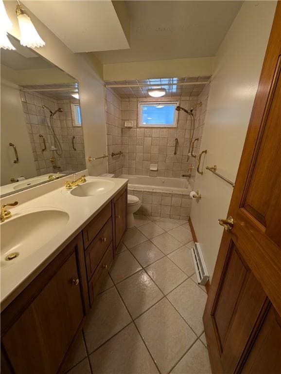 bathroom featuring tile patterned flooring, double vanity, tiled shower / bath combo, and a sink