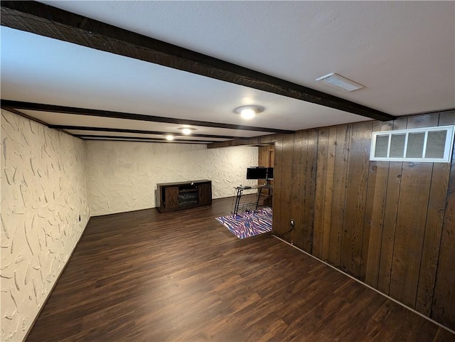 finished basement with visible vents, wood finished floors, and a textured wall