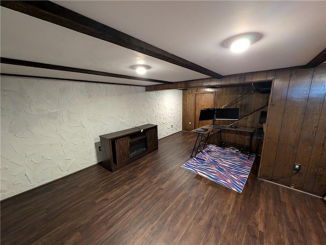 office with beam ceiling, wooden walls, a textured wall, and wood finished floors