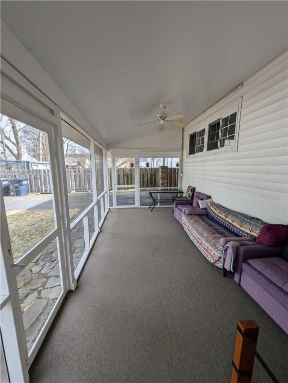 sunroom with ceiling fan and vaulted ceiling